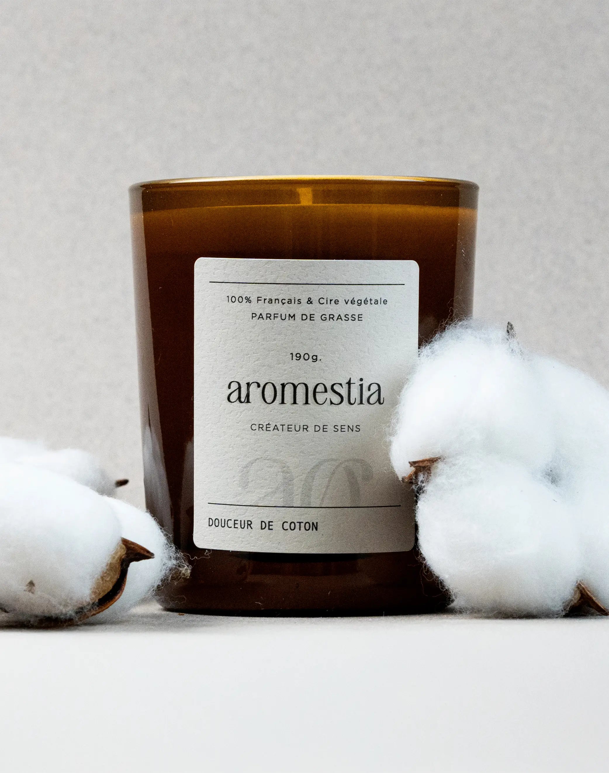 Bougie fleur de coton Aromestia avec un contenant ambré et du coton autour
