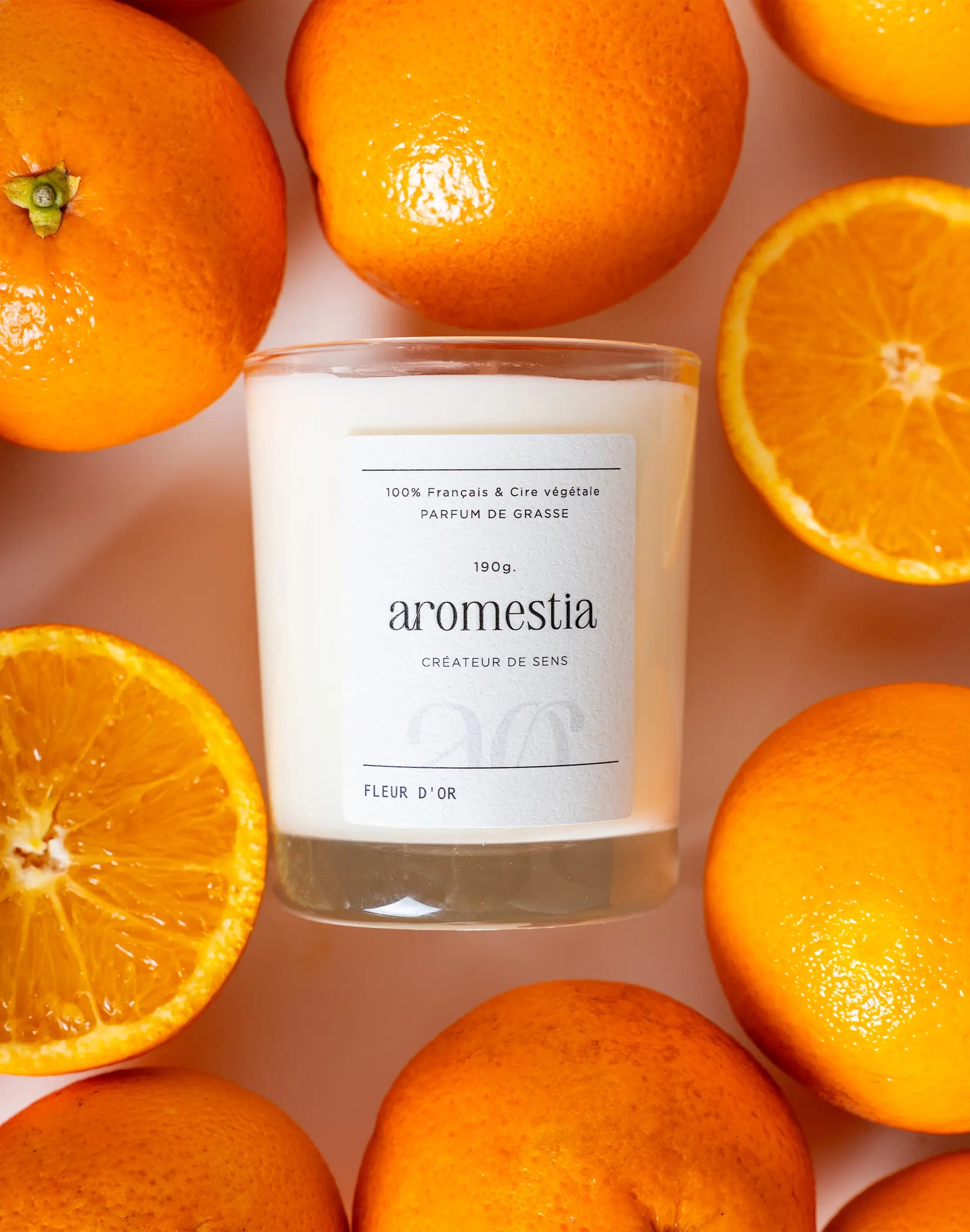 Bougie fleur d'or Aromestia avec des oranges autour