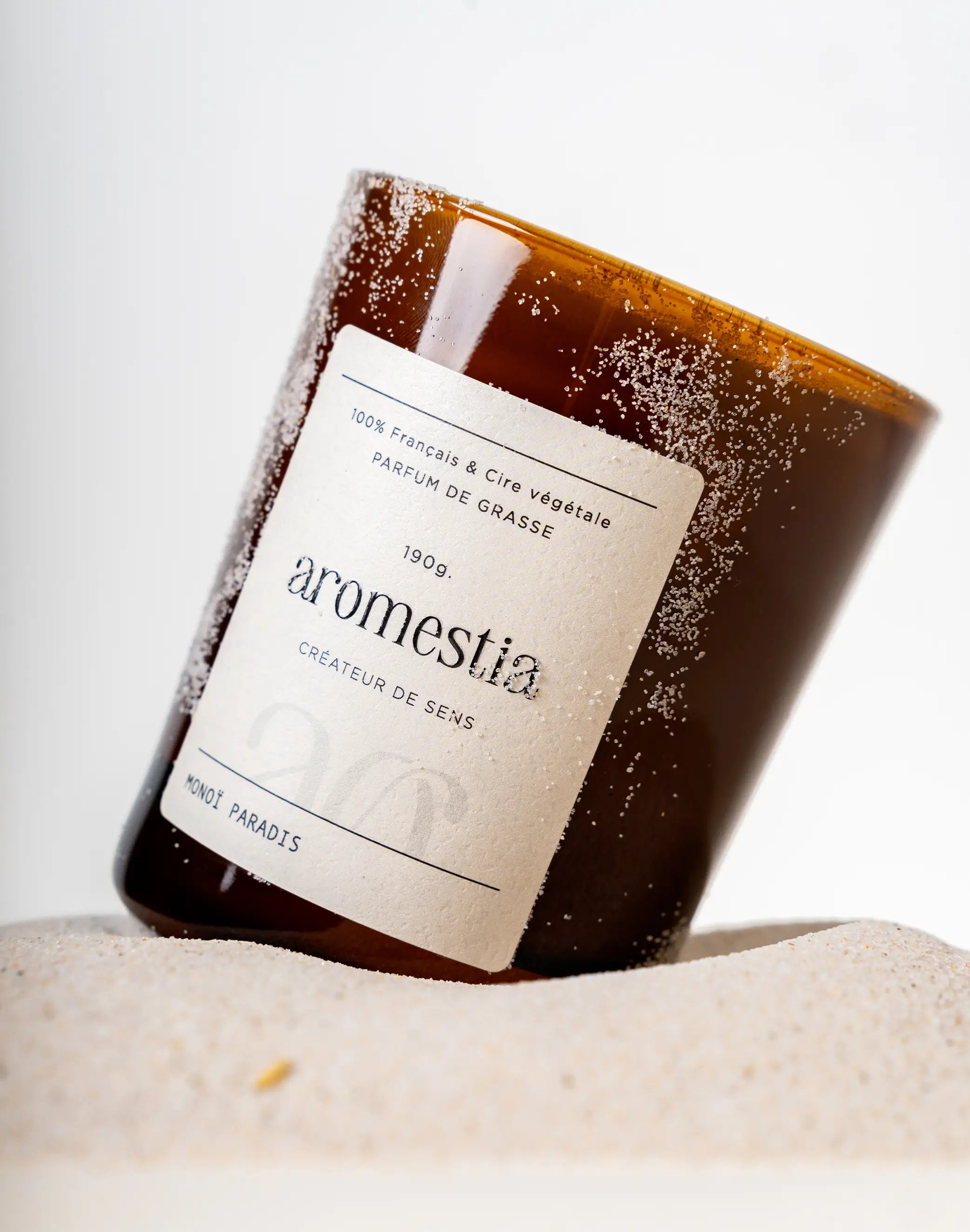 Bougie au monoï avec du sable